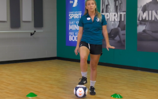 soccer coach with foot on ball