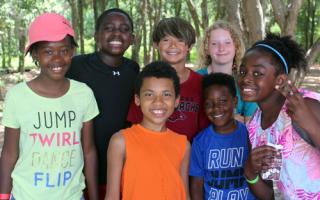 Seven kids pose together under the trees at Tampa Y's Camp Cristina.