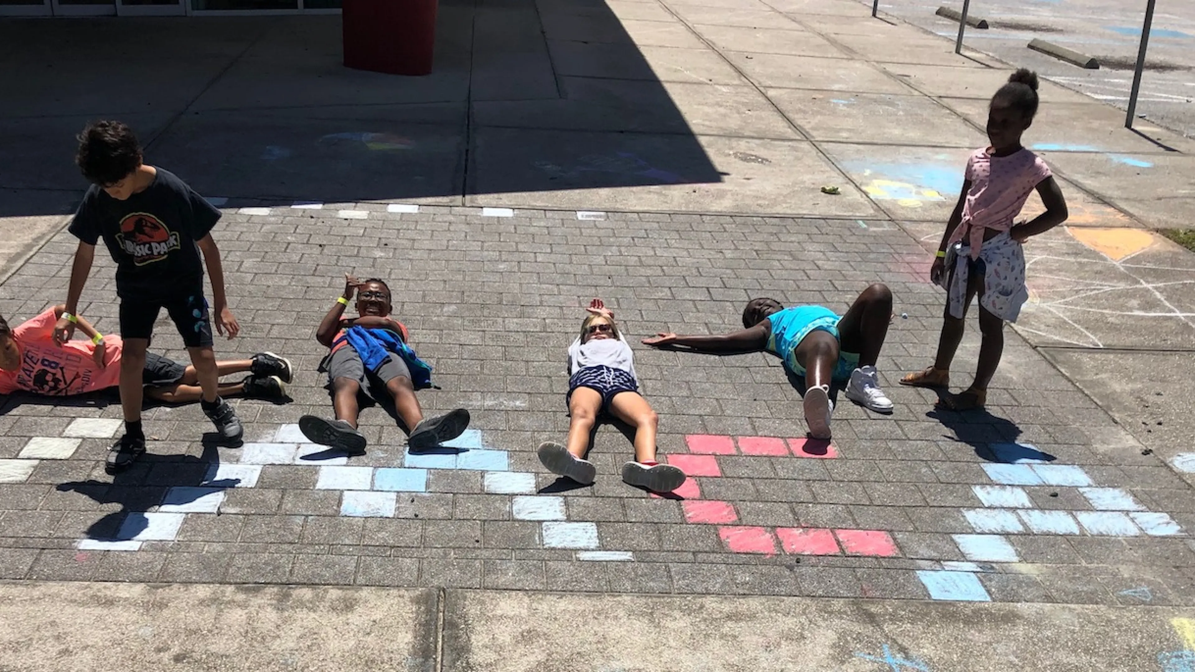 kids playing with chalk spelling ymca