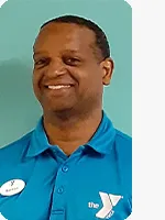 headshot of male personal trainer wearing blue YMCA polo green background