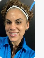 headshot of female personal trainer wearing blue YMCA polo black background