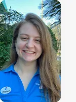 headshot of female personal trainer wearing blue YMCA polo tree background