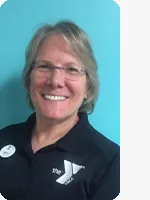 headshot of female personal trainer wearing black YMCA polo teal background