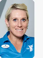 headshot of female trainer wearing blue YMCA polo gray background