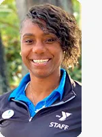 headshot of trainer wearing blue polo and black ymca jacket with white logo tree background