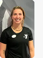 headshot of female personal trainer wearing black YMCA shirt gray background