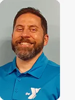 headshot of male personal trainer wearing blue YMCA polo gray background